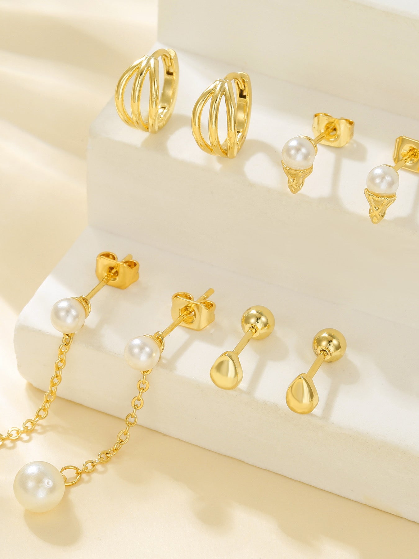 Styled view of pearl drop piercing set — 18k gold-plated curated pearl earrings for bridal and gifting.