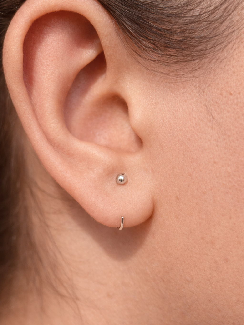 Pair of sterling silver ball hoop earrings — minimalist poke-free hoops, safe for kids and sensitive skin.