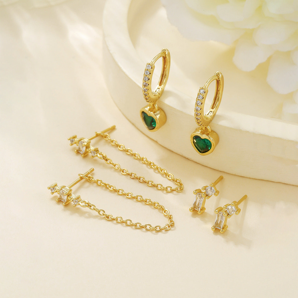Close-up of green heart piercing earrings — 18k gold-plated curated set for evening and everyday looks.