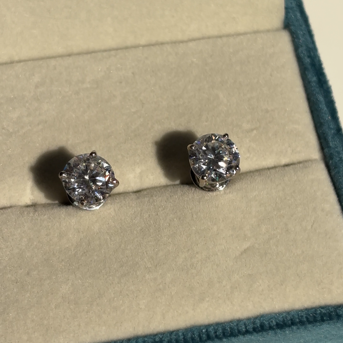 Close-up of solitaire moissanite stud earrings — VVS1 sterling silver studs for everyday-luxury bridal styling.